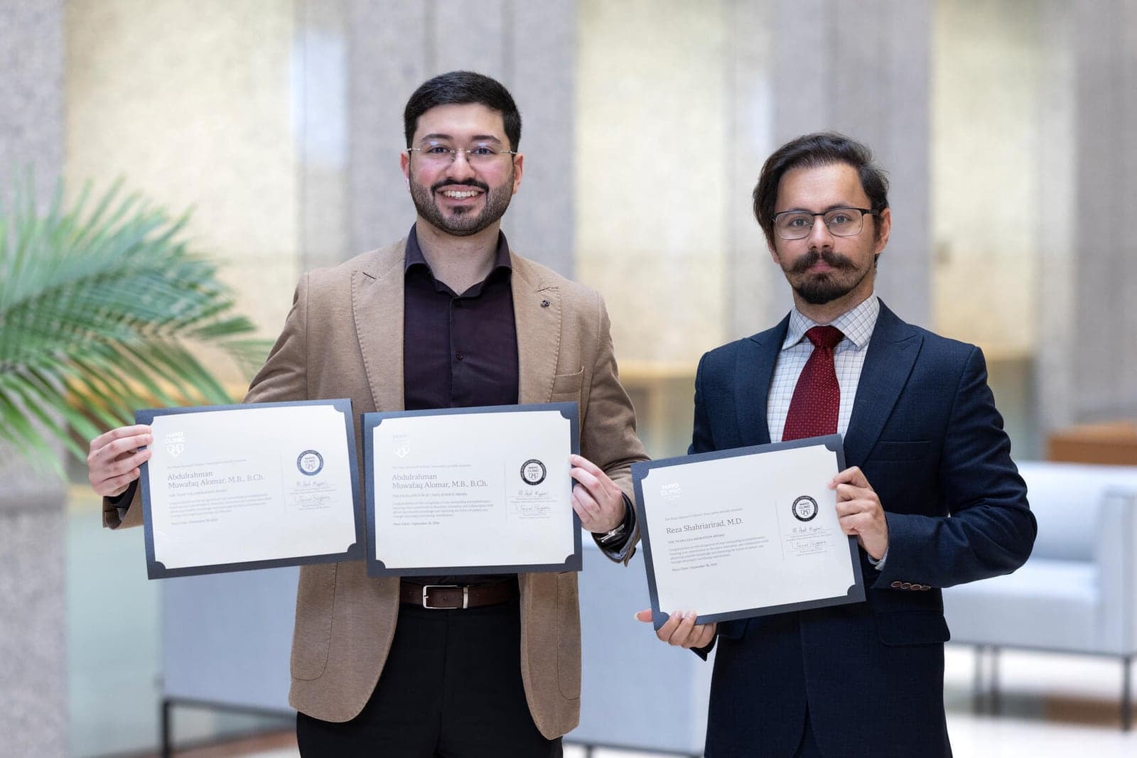 Dr. Abdulrahman Alomar and Dr. Reza Shahriarirad holding their Mayo Research Fellows' Association award certificates.