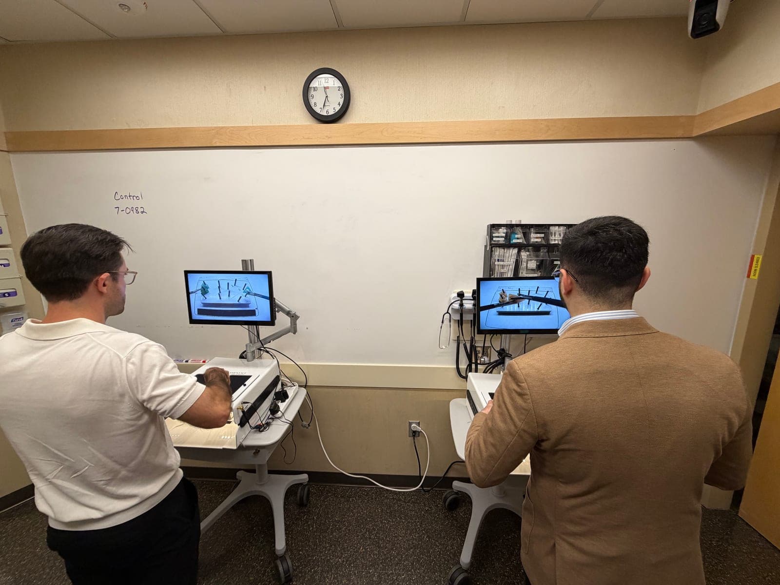 Two participants working through laparoscopic tasks on box trainers at Surgery Family Day.