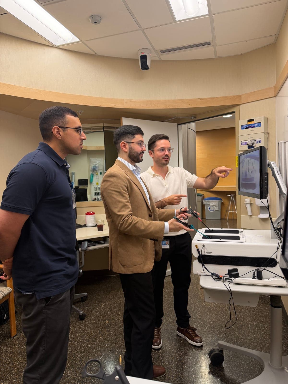 Dr. Simon J. Laplante and Dr. Abdulrahman Alomar demonstrating laparoscopic instruments to a visitor.